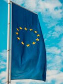 Produktregulierung Die EU-Fahne weht vor Schäfchenbewölktem Himmel
